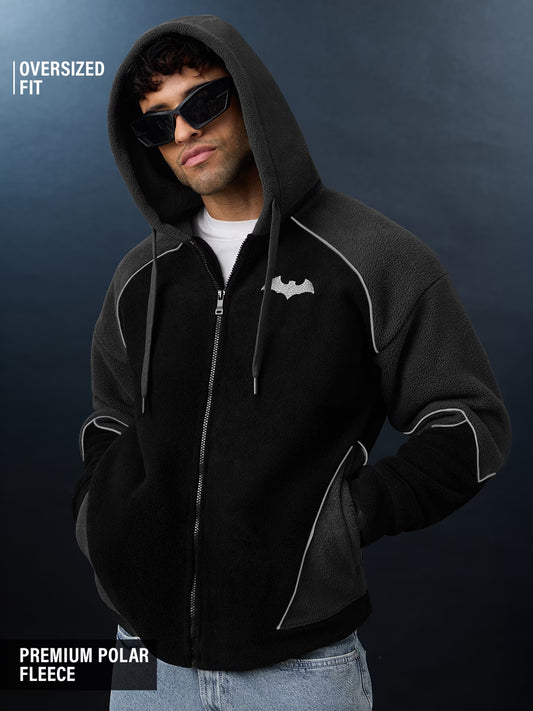 Man wearing a black hoodie with white accents on a dark background